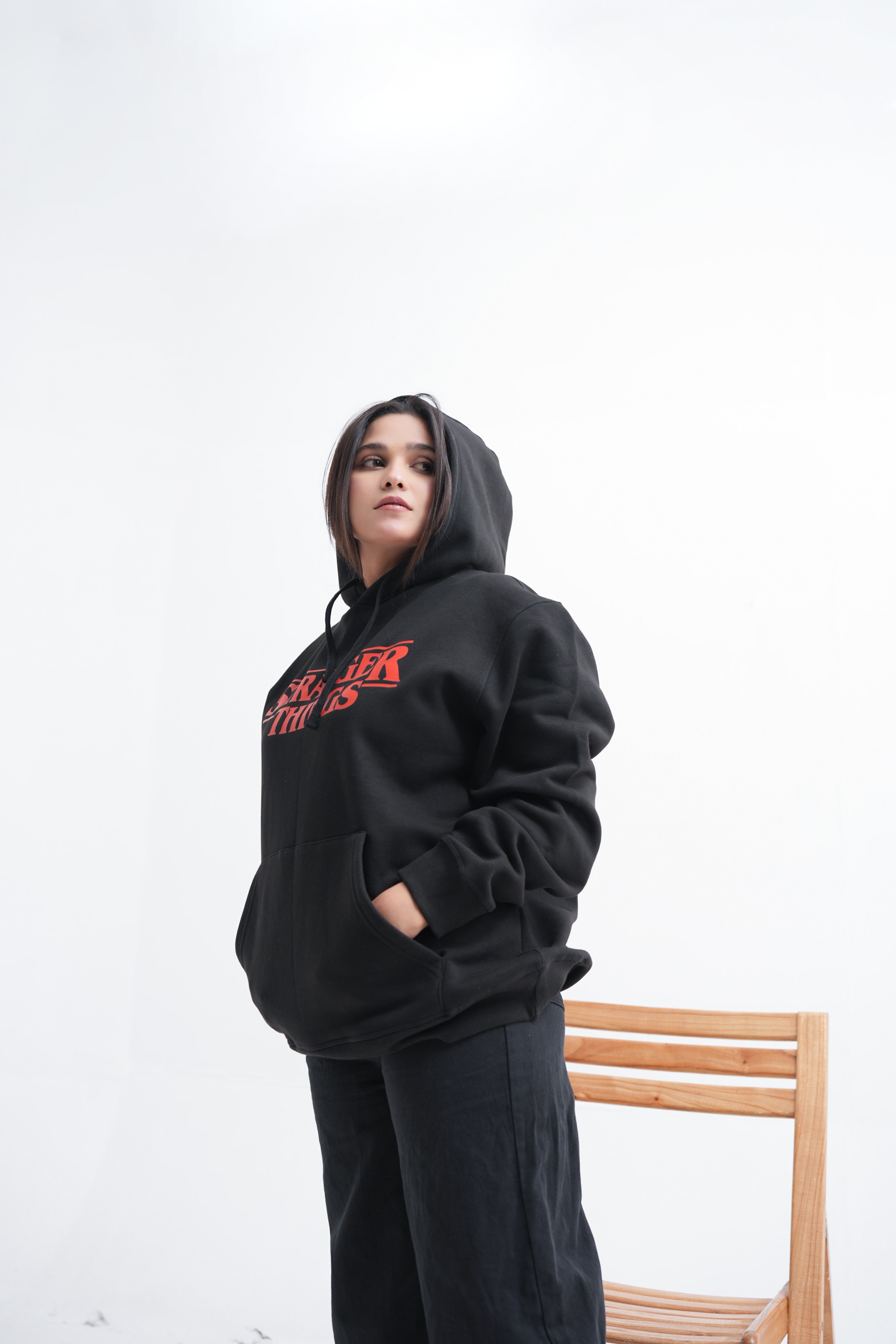 Unisex black hoodie with a Stranger Things graphic on the chest: