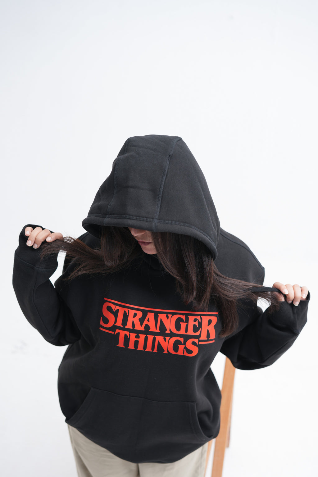 Unisex black hoodie with a Stranger Things graphic on the chest: