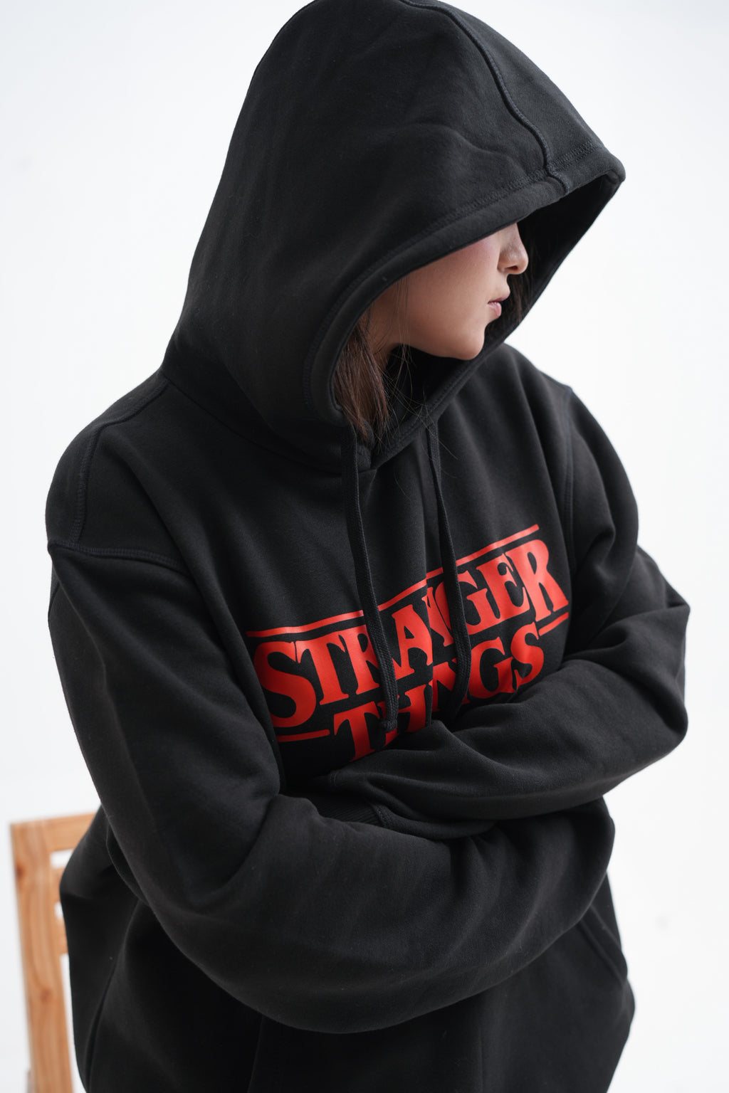 Unisex black hoodie with a Stranger Things graphic on the chest: