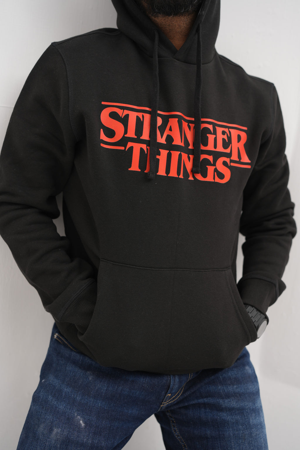 Unisex black hoodie with a Stranger Things graphic on the chest:
